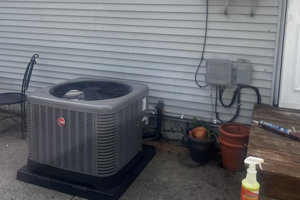 New central air conditioner condenser installed on a pad beside a home by J&K Heating & Cooling