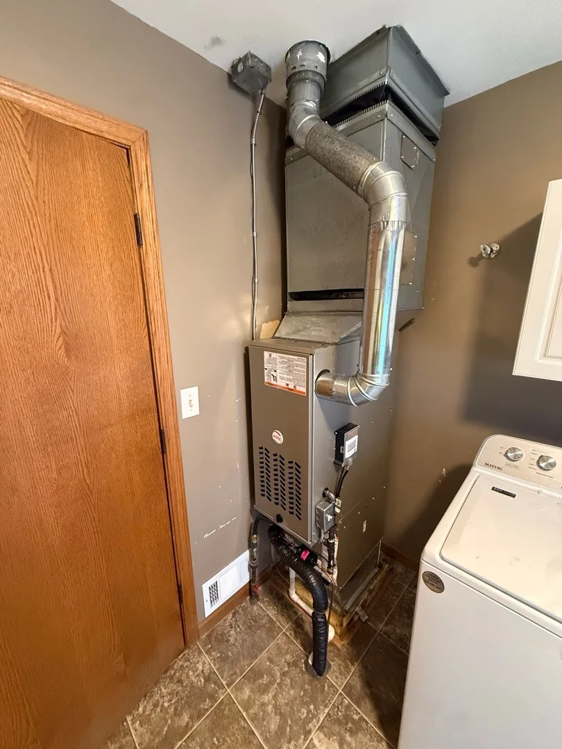 New gas furnace and venting installed in a laundry room