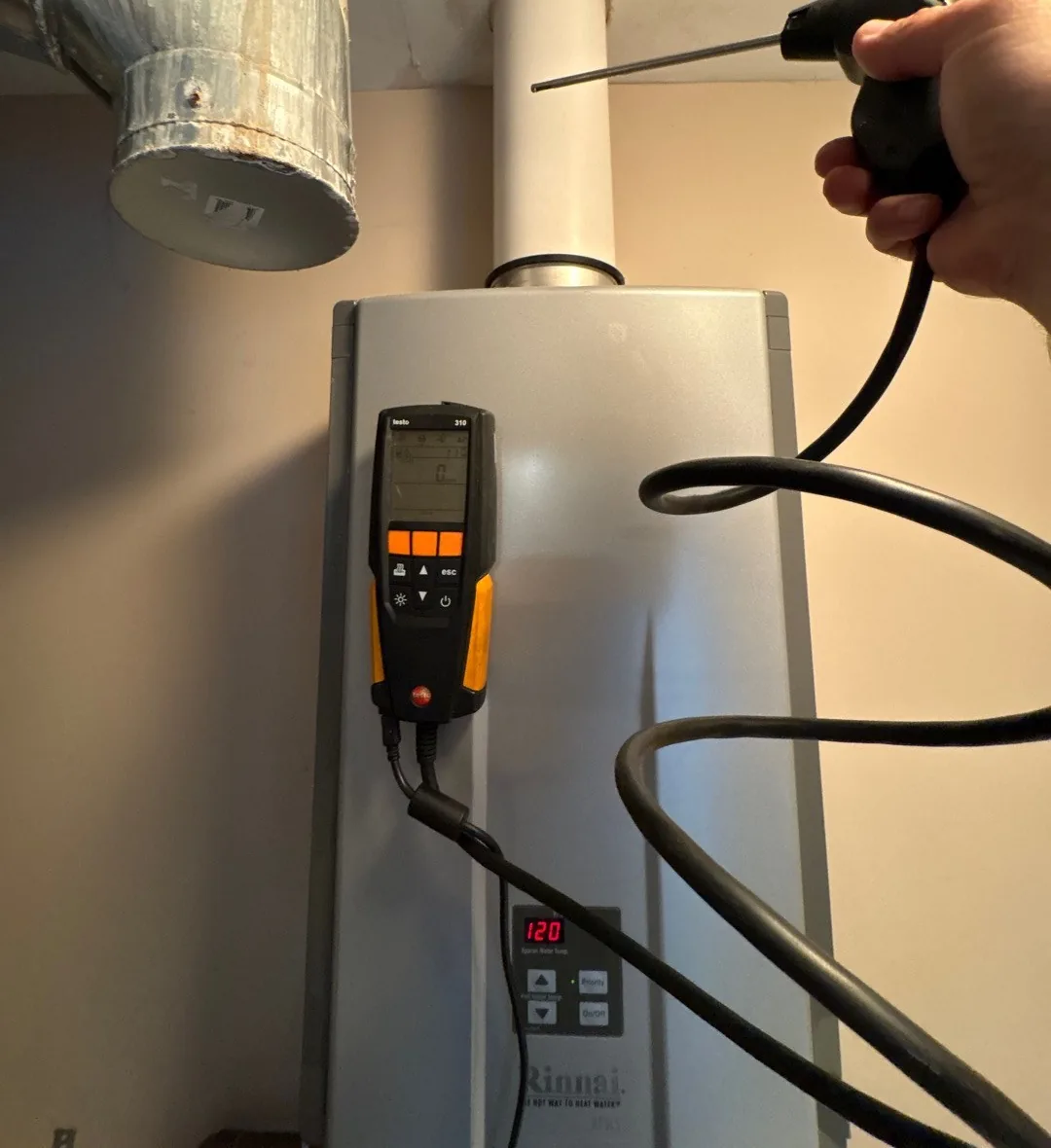 Technician testing for carbon monoxide at a tankless water heater