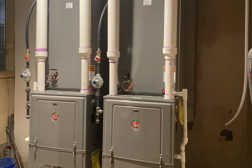 Two new high-efficiency gas furnaces installed side by side in a basement